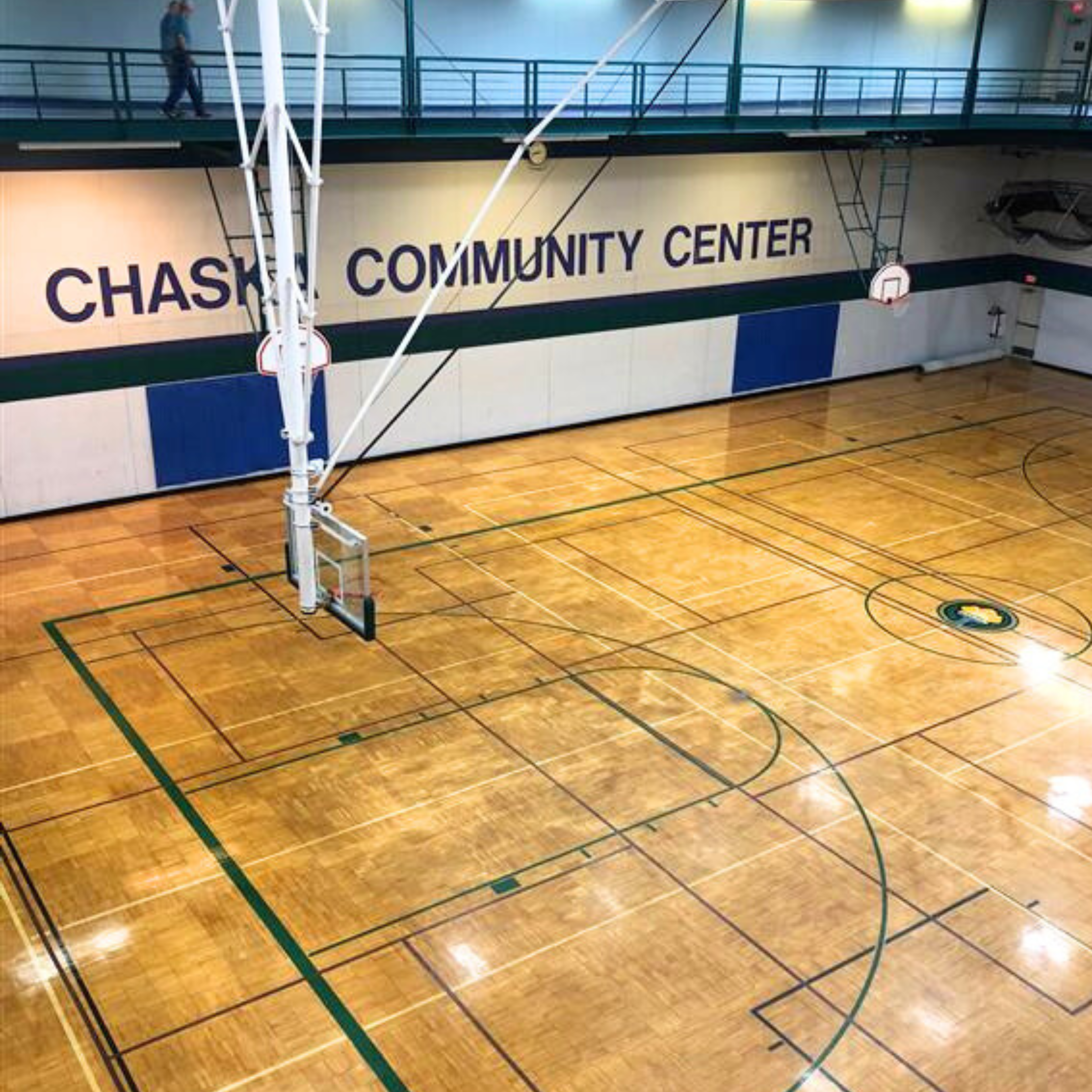 View from above of the lower gym featuring the word Chaska Community Center on the wall in purple